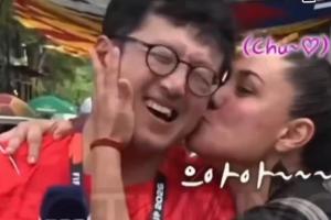 热情女球迷逗趣:韩国记者墨西哥世界杯报道中被粉丝拥吻脸颊